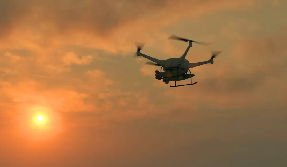 Drone flying in sunset sky